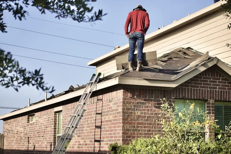 Professional roofer working on a residential roof in Airport North